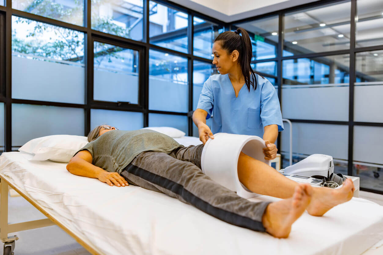 Woman getting magnetic field therapy on her knee by her sports medicine doctor