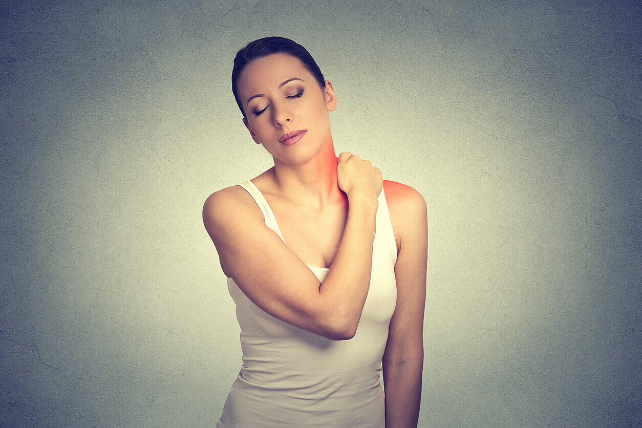 A woman is experiencing pain in her neck and shoulder, which are colored red due to a rotator cuff injury.