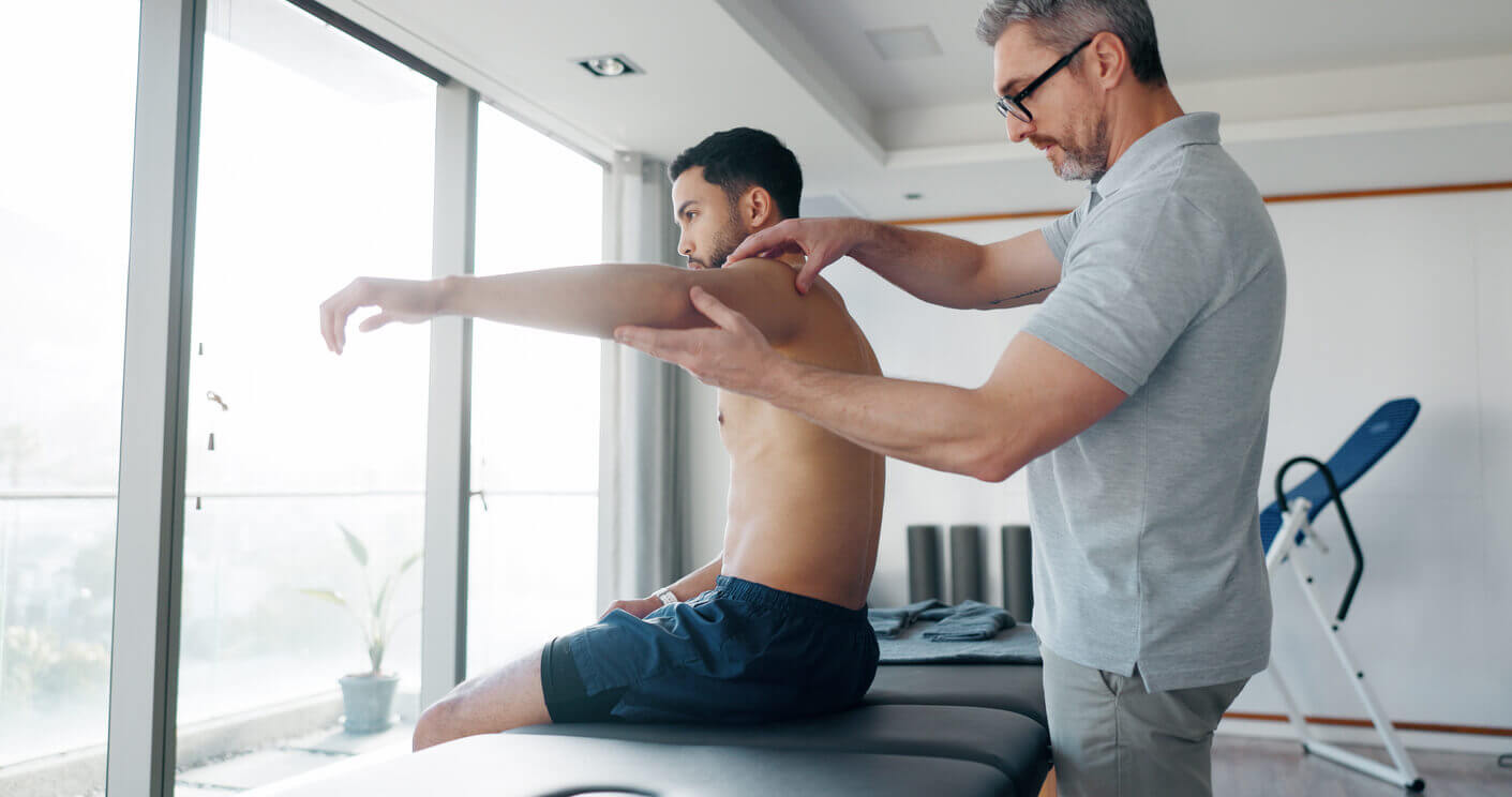 A sports medicine doctor is assessing the athlete's shoulder at the clinic.